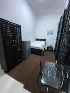 a room with a bed and a table and a bedroom at Four Stars Residence in Dubai