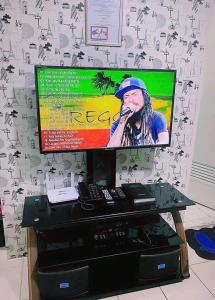 Una pantalla de televisión con una mujer hablando por un micrófono. en 888staykzion, en Manila