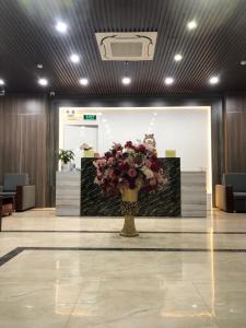 a lobby with a vase of flowers on the floor at Queenie Hotel in Hai Phong