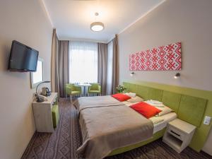 pokój hotelowy z łóżkiem i telewizorem w obiekcie Hotel *** NAT Krynica Zdrój w mieście Krynica Zdrój +37 zdjęć