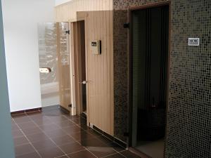 a row of stalls in a bathroom with brown tiles at Dafovska Hotel in Pamporovo