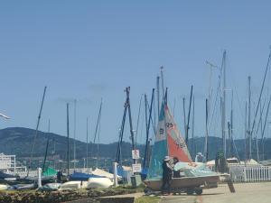 克尼斯纳The Little Mermaid Knysna houseboat的两人站在码头的帆船旁边