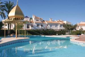a swimming pool in front of a large house at Townhouse med takterrass i Costa Hispania in Gran Alacant
