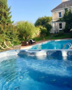 Una piscina con agua azul en un patio. en Tarka Woodland Cabin, en Littleham
