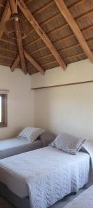 a bedroom with two beds and a wooden ceiling at Casa de campo, La Resolana in Rivera