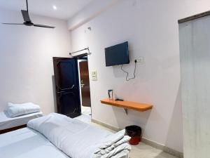 a bedroom with two beds and a tv on the wall at Maa durga home stay in Faizābād
