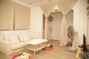 a living room with a white couch and a table at Friend's House Arak in Chiang Mai