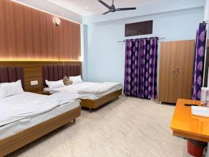 a hotel room with two beds and a desk at Maa durga home stay in Faizābād