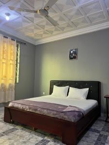 a bedroom with a bed with a ceiling at Renda Residence Apartment in Takoradi