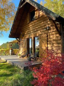 a log cabin with a porch and benches on a deck at Czuła Chata Ojców in Prądnik Czajowski