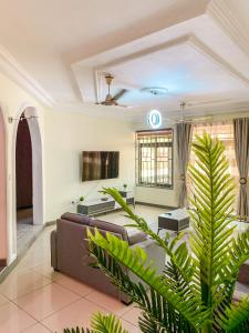 a living room with a couch and a tv at Renda Residence Apartment in Takoradi