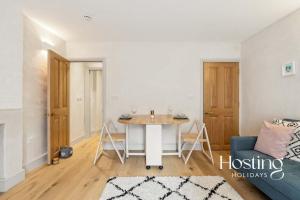 ein Wohnzimmer mit einem Tisch und einem blauen Sofa in der Unterkunft The Loft - 1 Bed Luxury Apartment with Bathtub in Henley on Thames