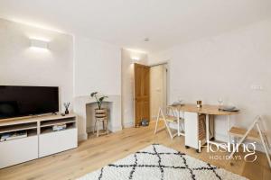 a living room with a television and a table at The Loft - 1 Bed Luxury Apartment with Bathtub in Henley on Thames