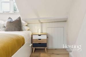 ein kleines Schlafzimmer mit einem Bett und einem Nachttisch in der Unterkunft The Loft - 1 Bed Luxury Apartment with Bathtub in Henley on Thames + 12 Fotos