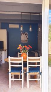 d'une table avec deux chaises et d'un vase avec des fleurs. dans l'établissement studio 33 m2 au calme proche HYERES, à La Crau