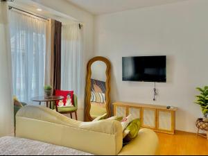 a living room with a couch and a tv at M&B Tropical 3-Bedroom Townhouse at PonteFino Prime in Batangas City
