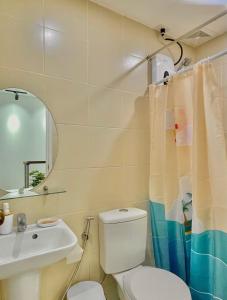 a bathroom with a toilet and a sink and a mirror at M&B Tropical 3-Bedroom Townhouse at PonteFino Prime in Batangas City