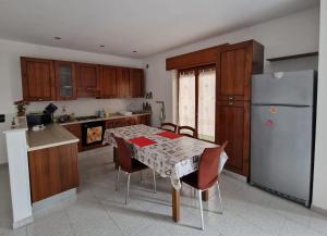 a kitchen with a table with chairs and a refrigerator at Vista Monte Retreat in Reggio di Calabria