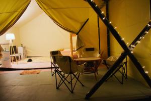 a room with a table and chairs in a tent at Hawun Glamping with Private Pool in Tamparuli