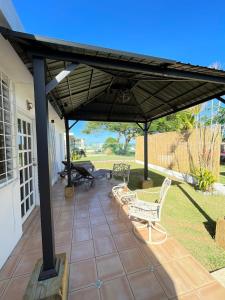 a patio with two chairs and an umbrella at Cozy house with sea view! in Luquillo