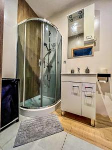 a bathroom with a shower and a sink at Wodna 16 premium in Konin