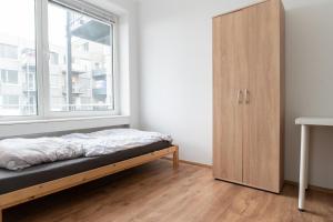 a bed in a room with a window and a cabinet at Helle Wohnung mit Balkon perfekt für Monteure und Arbeiter in Rüsselsheim