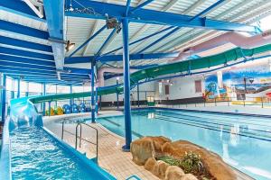 a swimming pool with a water slide in a building at Trecco Bay Cwtch Caravan in Newton