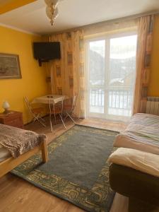 a bedroom with a bed and a table and a window at Pokoje gościnne u Faronow in Muszyna
