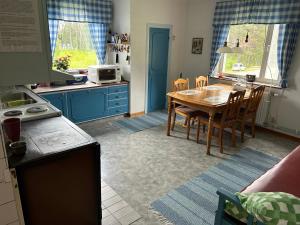 a kitchen with a wooden table and a kitchen with blue cabinets at Holmsel in Vidsel