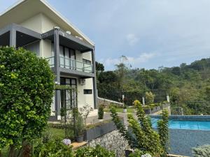 a house with a swimming pool in front of it at Moragolla Estate Bungalow Kothmale in Gampola