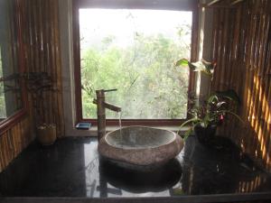 ein Badezimmer mit einem Steinwaschbecken und einem Fenster in der Unterkunft PuBinSpiceHills Perilla in Hòa Bình