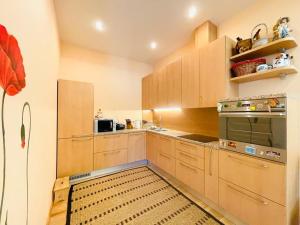 a kitchen with wooden cabinets and a refrigerator at Amazing location next to the beach jomas str in Jūrmala