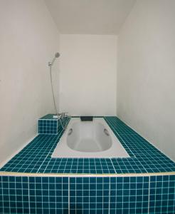 a bathroom with a tub with blue tiles on the floor at Tani Ryu River Kwai in Ban Tha Pong (1)