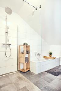 a white bathroom with a shower and a sink at Ferienwohnung Muthenthaler, Wachau in Schwallenbach