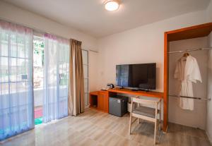 a living room with a tv and a chair and a television at Tani Ryu River Kwai in Ban Tha Pong (1)