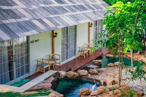 a house with a koi pond in the yard at Tani Ryu River Kwai in Ban Tha Pong (1)