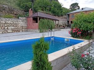 a swimming pool in a yard with a house at Green garden Կանաչ այգի in Ijevan