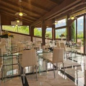 a dining room with tables and chairs and windows at Rossi&Nero Resort - servizi extra a pagamento Ristorante Piscina Sauna Spa in Pasquarelli