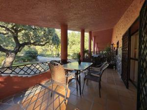 a patio with a table and chairs on a balcony at La Fuente del Pedregal Casa 1 - Lago y piscinas in Málaga +54 photos