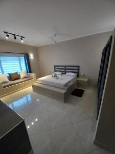 a bedroom with a large bed and a couch at Villa SunShine exclusive in Watamu