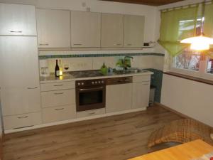 a kitchen with white cabinets and a stove top oven at Ferienhaus Schwinger in Böbrach