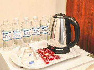 a tea kettle on a plate next to bottles of water at Jawad Al-Taj Hotel in Mecca