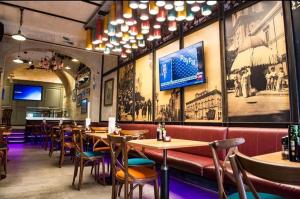 a restaurant with tables and chairs and a tv on the wall at Luciano Valletta Boutique in Valletta