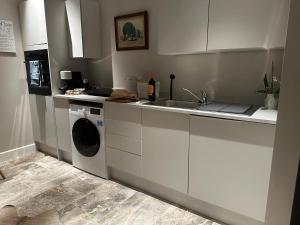 a kitchen with a sink and a washing machine at The Nook in Keynsham