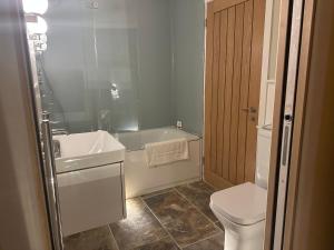 a bathroom with a tub and a toilet and a sink at The Nook in Keynsham