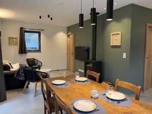 een woonkamer met een houten tafel en stoelen bij Les midis au vert - La Bâtisse - 4 personnes in Stavelot +7 foto's