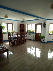a living room with a table and chairs and windows at Casa cu Flori in Mila Douăzeci şi Trei