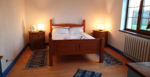 a bedroom with a wooden bed with two night stands at Casa cu Flori in Mila Douăzeci şi Trei +4 photos