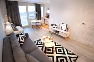 ein Wohnzimmer mit einem Sofa und einem Tisch in der Unterkunft Apartament Horizon in Gdynia