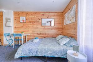 - une chambre avec un lit et un mur en bois dans l'établissement Studio Himalaya-Au coeur de la ville, à Palaiseau